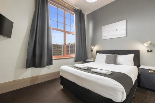 a bedroom with a large bed and a window at Adelaide Paringa in Adelaide