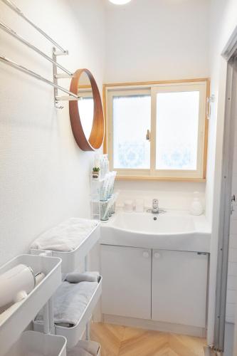 a white bathroom with a sink and a mirror at KOEDO MINAMI noyado in Kawagoe
