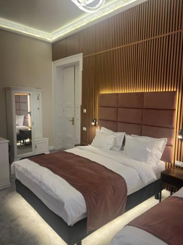 a bedroom with a large bed with a large headboard at Bucharest Downtown Inn in Bucharest