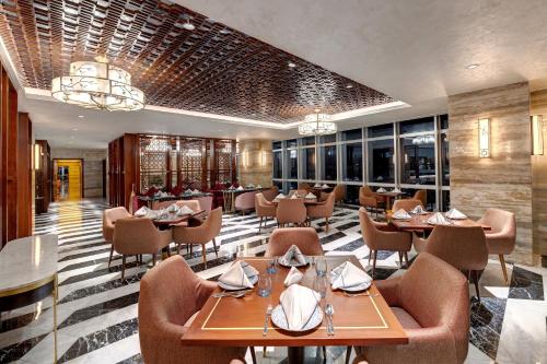 a restaurant with tables and chairs in a room at Movenpick Hotel Centaurus Islamabad in Islamabad