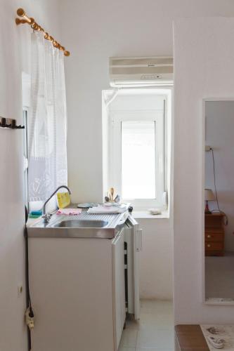 a kitchen with a sink and a window at Spiros Apartments in Livadia