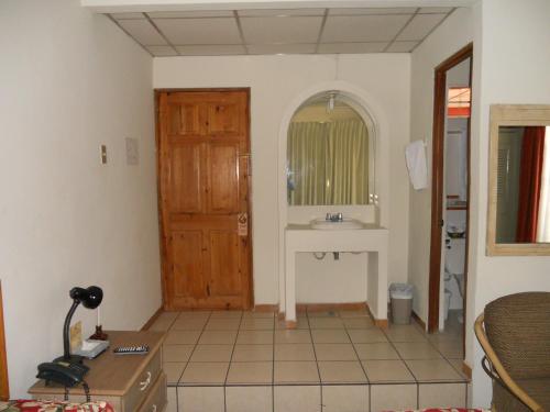 ein Badezimmer mit Waschbecken und Spiegel in der Unterkunft Hotel Mediterraneo Plaza in San Salvador