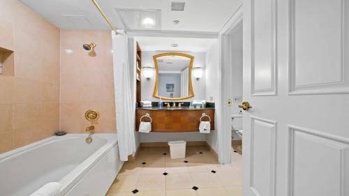 a bathroom with a tub and a sink and a mirror at CozySuites Modern Studio Condo at Showboat #29 in Atlantic City