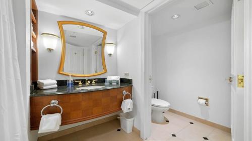 a bathroom with a sink and a mirror and a toilet at CozySuites Modern Studio Condo at Showboat #29 in Atlantic City
