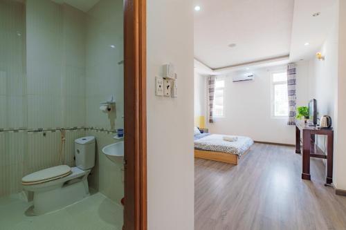 Un baño con inodoro, lavabo y cama. en NEWROOM-1km 2 Bui Vien, en Ho Chi Minh