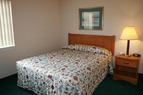 a bedroom with a bed and a table with a lamp at Affordable Suites Myrtle Beach in Myrtle Beach