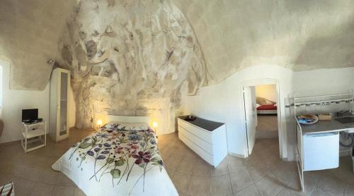 a bedroom with a bed in front of a stone wall at Agorà nei sassi in Matera
