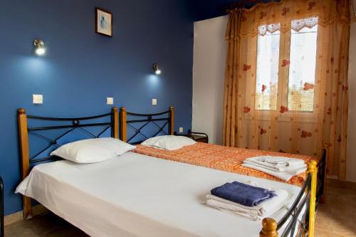 a bedroom with a bed with white sheets and a blue wall at Summer Dream in Anaxos