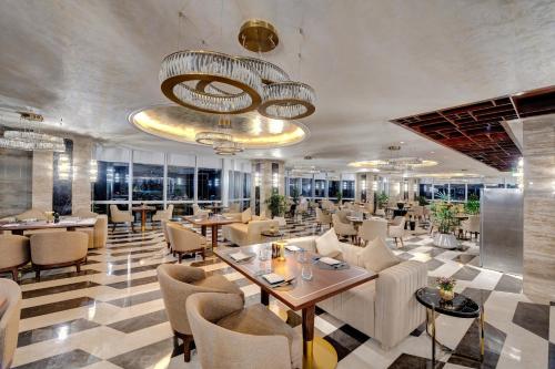 a restaurant with tables and chairs and a chandelier at Movenpick Hotel Centaurus Islamabad in Islamabad