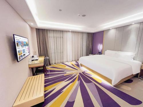 a bedroom with a large bed and a colorful carpet at Lavande Hotel Huizhou Shiwan in Huizhou