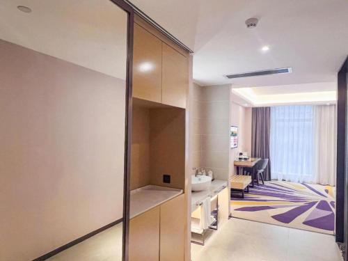 a room with a bathroom with a sink and a mirror at Lavande Hotel Huizhou Shiwan in Huizhou
