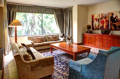a living room with a couch and a table at The Links Guest House in Pretoria