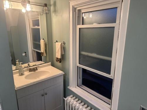 Un baño con lavabo y ventana. en Maple Falls Oasis By Tig Management, en Niagara Falls