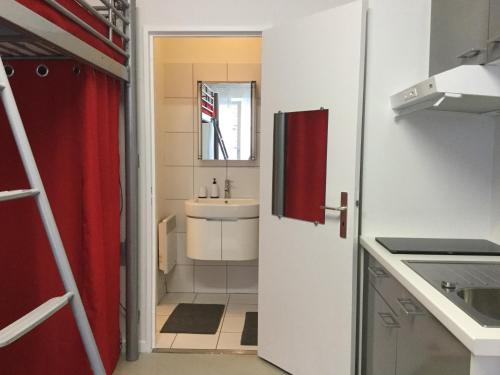 - une petite cuisine avec un évier et un miroir dans l'établissement Studio sur cour au coeur de Colmar, à Colmar