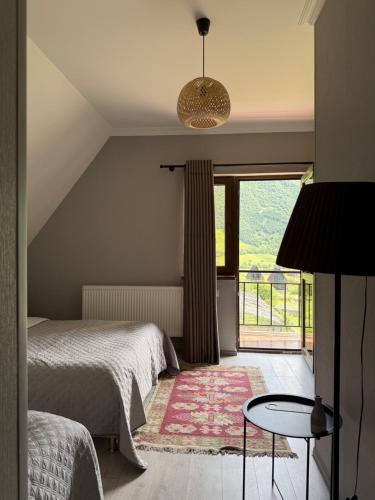 a bedroom with two beds and a large window at OISHE Boutique Hotel in Stepantsminda