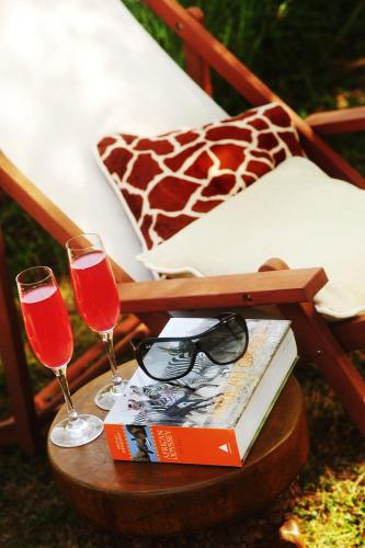 - une table avec deux verres de vin et un livre dans l'établissement Kimaro Farmhouse, à Colméry