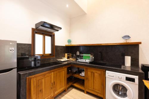 a kitchen with a sink and a washing machine at Nomada Villas in Kuta Lombok