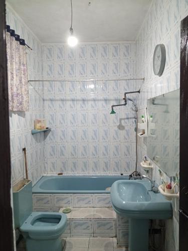 a bathroom with a blue tub and a toilet and a sink at Kandy Nest Stay Home in Kandy