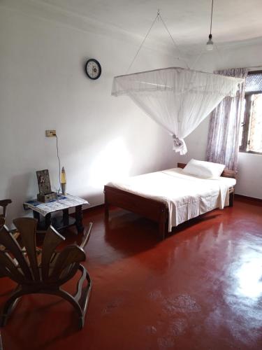 a bedroom with a bed with a mosquito net on the wall at Kandy Nest Stay Home in Kandy