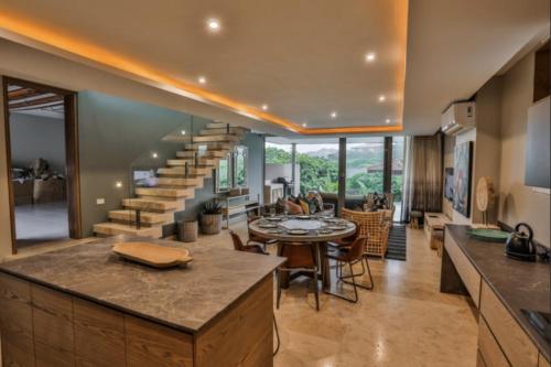 an open kitchen and living room with a spiral staircase at Luxury 4BR Home with Ocean Views, Pool and Hot Tub in Ballito