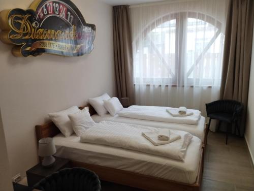 a hotel room with two beds and a window at Régi Posta Hotel és Étterem in Debrecen