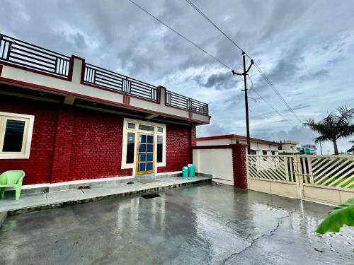 a red brick house with a blue door at Athulyam Homes in Dehradun