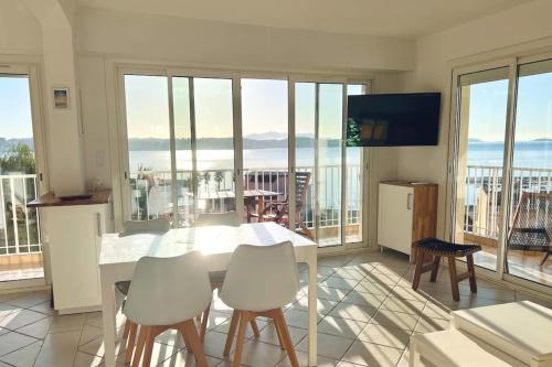 cocina con mesa y sillas y vistas al océano en La trouvaille - port et mer grand balcon parking, en Bandol