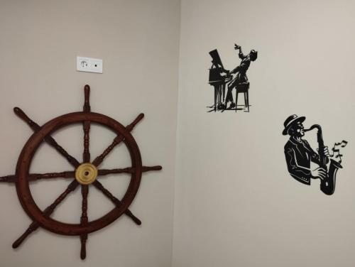 a clock on a wall next to a wooden wheel at Régi Posta Hotel és Étterem in Debrecen