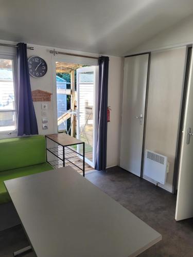 - un salon avec une table et un canapé vert dans l'établissement Camping Le Hameau Des Pécheurs, à Novalaise