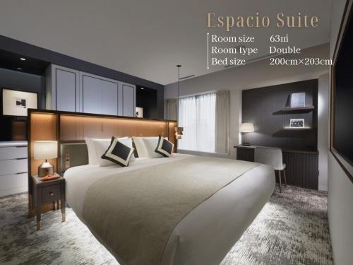 a hotel room with a large bed and a desk at Nagoya Kanko Hotel in Nagoya
