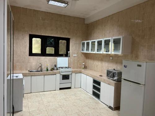 a large kitchen with white cabinets and appliances at Holiday Villa in Nikawatawana