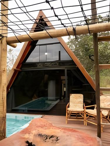 a house with a glass roof and a pool at Espaço Gaia in Santana do Riacho