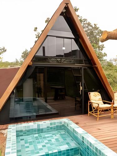 a house with a thatched roof with a swimming pool at Espaço Gaia in Santana do Riacho