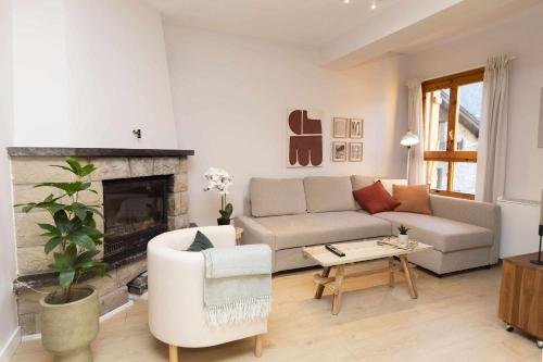 un soggiorno con divano e camino di Casa Josephine by BeValle a Panticosa