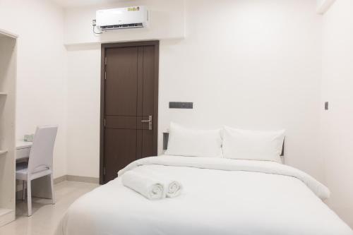 a bedroom with a white bed with two towels on it at Comfy Quite Private Room- Hulhumale in Hulhumale
