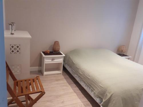 - une chambre avec un lit et un fauteuil en bois dans l'établissement Ambiance provençale, à La Seyne-sur-Mer