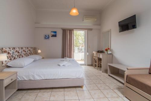 a bedroom with a bed and a desk and a television at Grameno Apartments in Kountoura Selino