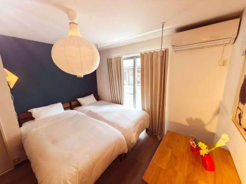 a bedroom with two beds and a table and a lamp at Mossy Nest Negishi I 鶯谷駅徒歩7分 上野徒歩圏内 in Tokyo