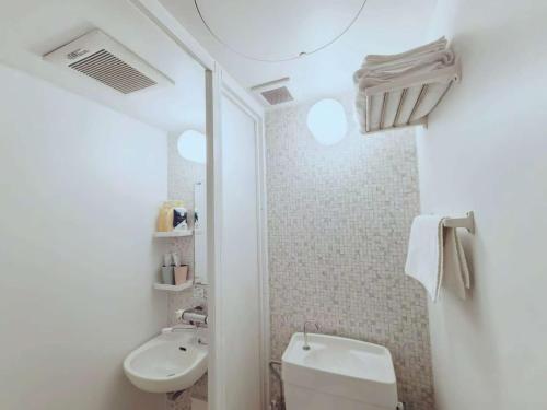 a white bathroom with a sink and a toilet at Mossy Nest Negishi I 鶯谷駅徒歩7分 上野徒歩圏内 in Tokyo