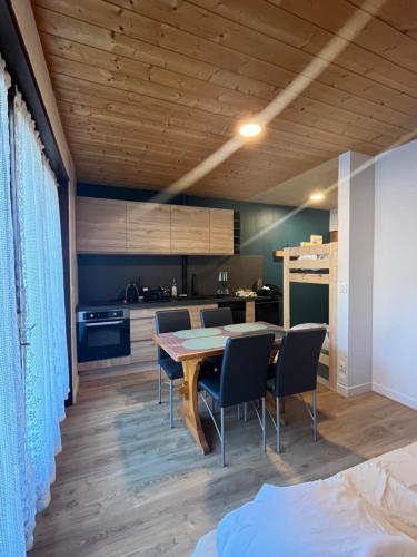 une cuisine et une salle à manger avec une table et des chaises dans l'établissement KEARL, studio neuf soleil et détente, aux Gets