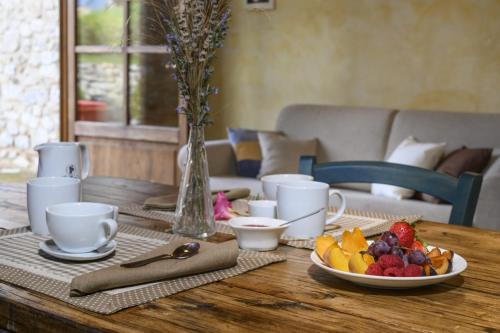 a wooden table with a plate of fruit on it at La Landuccia in Libbiano