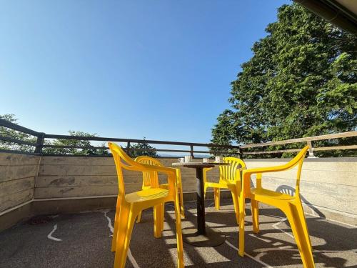 four yellow chairs and a table on a patio at 雲海坊 in Kannami