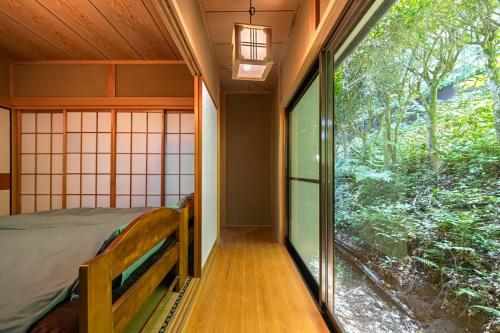 a room with a bed and a large window at 雲海坊 in Kannami