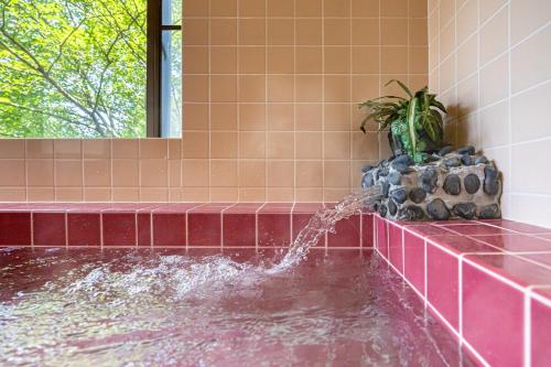 a bath tub with a water fountain in a bathroom at 雲海坊 in Kannami