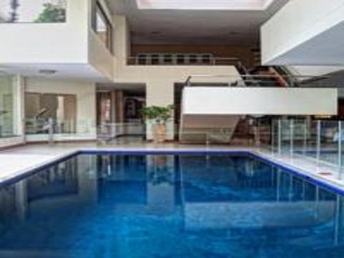 a large swimming pool with blue water in a building at The Links Guest House in Pretoria