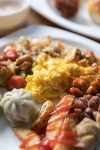a plate of food with scrambled eggs and vegetables at With Stay Jeju Hotel in Jeju