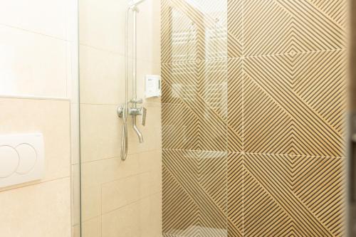 a shower with a glass door in a bathroom at Régi Posta Hotel és Étterem in Debrecen