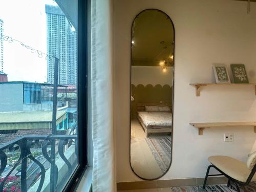 a mirror on a wall next to a window at Luxe Paradise 21 Nguyen Van Troi in Hanoi