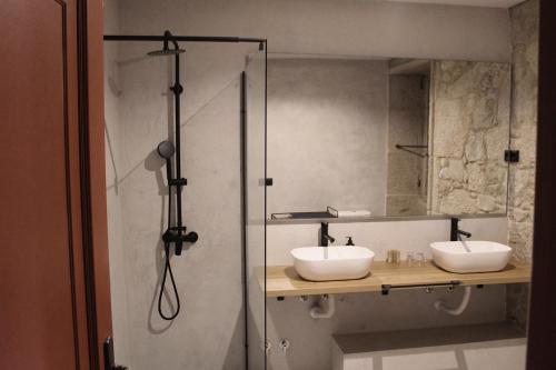 a bathroom with two sinks and a shower at Pazo da Buzaca in Moraña