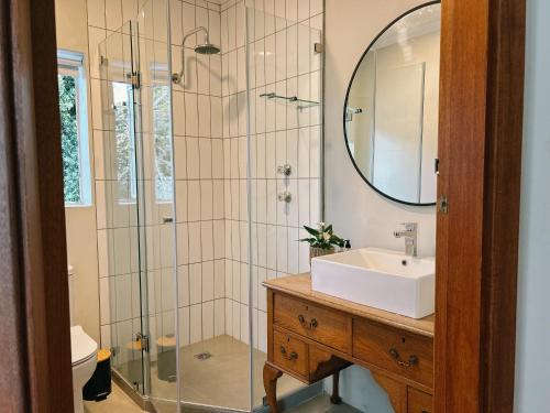 a bathroom with a sink and a shower with a mirror at Leisure Isle Loft Apartment in Knysna